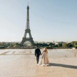 A bride and groom sharing a romantic moment in front of the iconic Eiffel Tower in Paris - Tour and Travel Agency