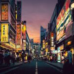 Explore the vibrant nightlife of Shibuya, Tokyo, showcasing neon-lit streets bustling with activity after sunset.